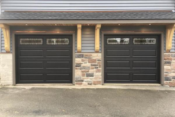Two single bay raised panel doors in black with Hawthorne Glass.