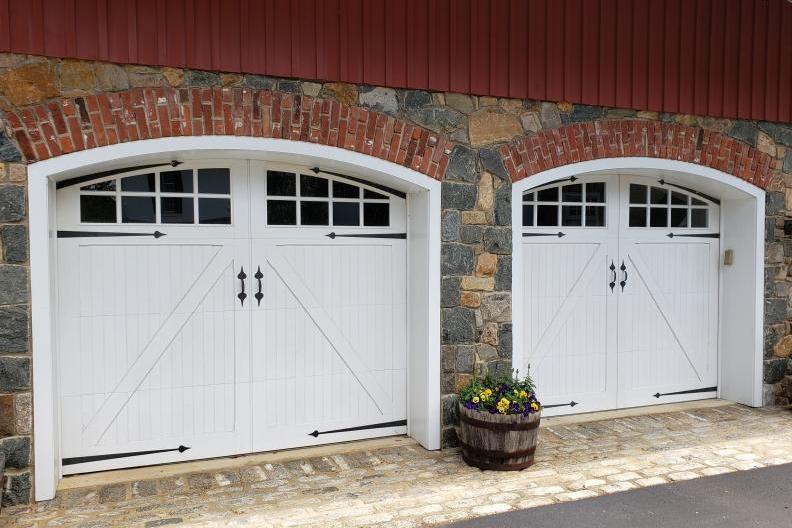 A pair of Artisan Custom Wood Doors in white with windows and hardware.